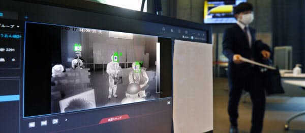 オフィスビルの受付ロビーに設置された、AIによる顔認証機能を備えた体温検知システム(3月17日、東京都千代田区)