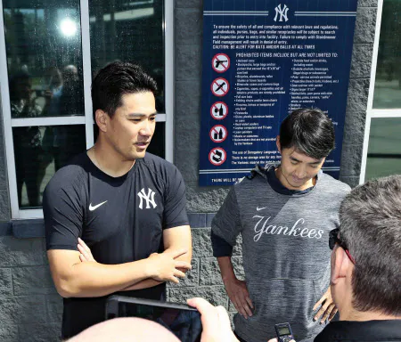 練習後、報道陣の取材に応じるヤンキースの田中将大投手(左)=15日、米フロリダ州タンパ(共同)