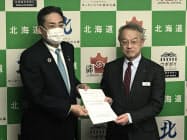 北海道観光振興機構の堰八義博会長(左)から要望書を受け取る北海道の土屋俊亮副知事(23日、札幌市) 北海道観光振興機構の堰八義博会長(左)から要望書を受け取る北海道の土屋俊亮副知事(23日、札幌市)