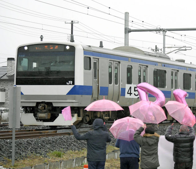 全線で運行を再開したJR常磐線の列車を迎える沿線住民(14日、福島県富岡町) 全線で運行を再開したJR常磐線の列車を迎える沿線住民(14日、福島県富岡町)