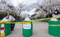 上野公園の「さくら通り」を封鎖する都職員（27日、東京都台東区）
