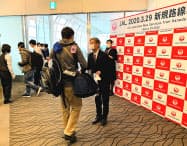 JALは赤坂祐二社長が乗客に記念品を渡し搭乗に感謝を示した JALは赤坂祐二社長が乗客に記念品を渡し搭乗に感謝を示した