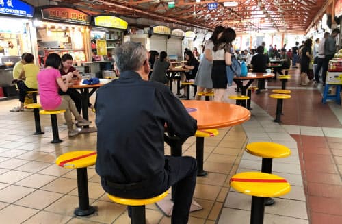 シンガポールで人々が接近しないよう、イスに着席禁止の印をつける飲食店も=岩本健太郎撮影