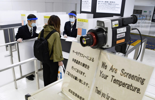 検疫官から質問を受ける米国便で到着した乗客=26日午後、成田空港 検疫官から質問を受ける米国便で到着した乗客=26日午後、成田空港