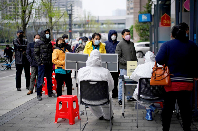銀行の入り口で順番を待つ市民(3月31日、中国湖北省武漢市)=ロイター 銀行の入り口で順番を待つ市民(3月31日、中国湖北省武漢市)=ロイター