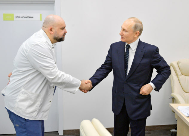 新型コロナ感染が確認された病院医長(左)と握手するプーチン大統領(24日、モスクワ)=AP 新型コロナ感染が確認された病院医長(左)と握手するプーチン大統領(24日、モスクワ)=AP