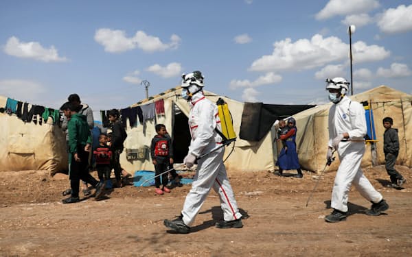 避難民が集まるキャンプで消毒作業を行う（3月26日、シリア北西部）=ロイター