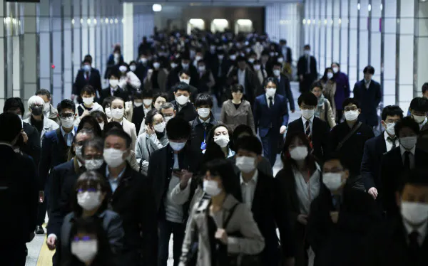 緊急事態宣言から一夜明け、マスク姿で通勤する人たち(8日午前)=中岡詩保子撮影
