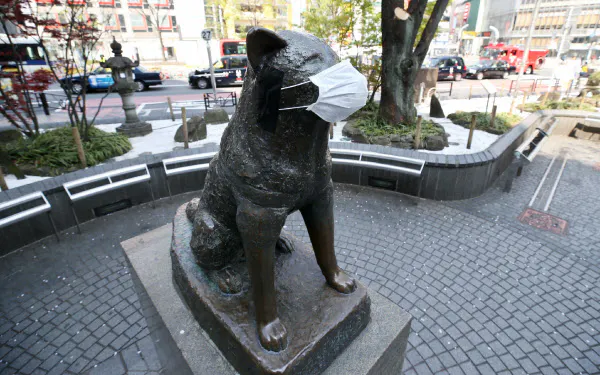 東京・渋谷の忠犬ハチ公像の口にはマスクが着けられています。スマホで像の写真を撮影した男性は、「買い置きしたマスクが足りなくなっているので、自分にも分けて欲しいくらいだ」と話した(8日午前)=樋口慧撮影