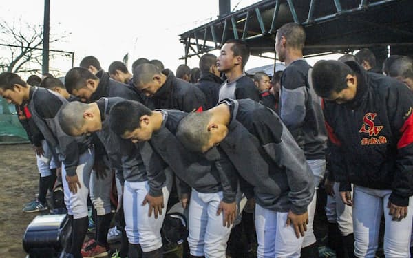選抜高校野球大会の中止決定後、練習を終えてグラウンドへ一礼する長崎・創成館高ナイン(3月11日)=共同