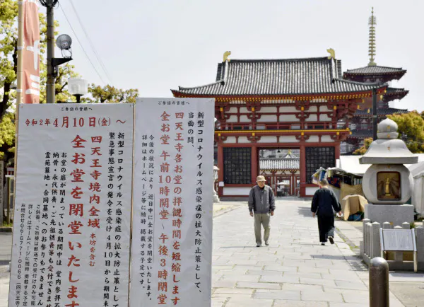 大阪市の四天王寺の境内に掲示された10日から全堂閉鎖を知らせる看板(左)=8日、共同