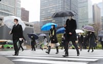 雨の中、通勤する人たち（13日午前、東京・丸の内）