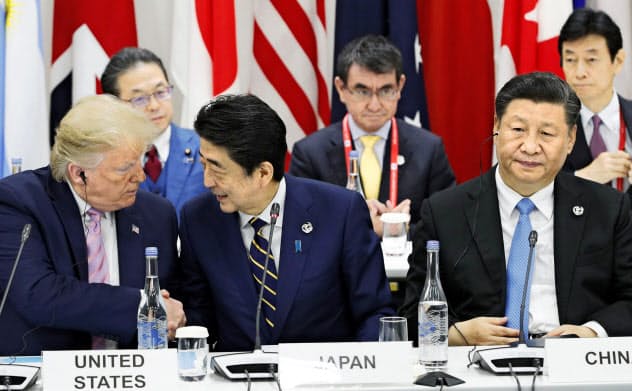 G20大阪サミットで握手するトランプ米大統領(左)と安倍首相。右は中国の習近平国家主席(2019年6月、大阪市)=共同 G20大阪サミットで握手するトランプ米大統領(左)と安倍首相。右は中国の習近平国家主席(2019年6月、大阪市)=共同