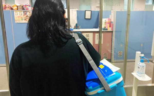 医療機関からウイルス検査用の検体を運ぶ保健師（東京都内）=一部画像処理しています