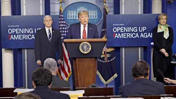 16日、記者会見に臨むトランプ氏(中央)=AP