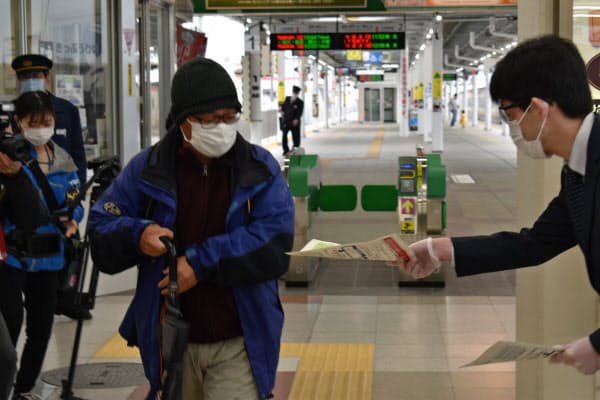 新幹線から降りた乗客にチラシを配る山形県の啓発活動(18日、JR山形駅)