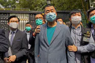 18日、自宅前で警察に連行される香港紙創業者の黎智英氏(中)=AP 18日、自宅前で警察に連行される香港紙創業者の黎智英氏(中)=AP
