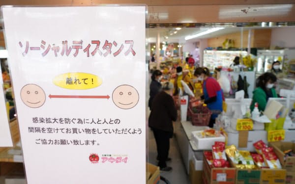 食品スーパーの入り口に張られた人との間隔を空けるように促す案内(東京都練馬区のアキダイ関町本店)