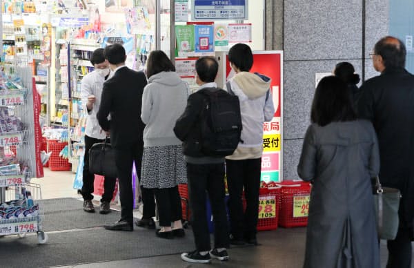 マスクを求め、開店したドラッグストアに並ぶ人たち(8日、東京都新宿区)