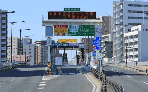 「不要不急の外出は自粛」と表示された首都高速道路の西池袋入り口(25日午前、東京都豊島区)