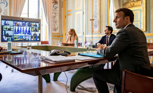 テレビ首脳会議に臨むマクロン仏大統領(23日、パリ)=ロイター