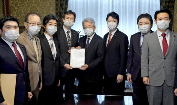 衆院の岡田憲治事務総長(中央右)に家賃支援法案を提出する国民民主党の後藤祐一氏(同左)ら野党議員(28日、国会)=共同