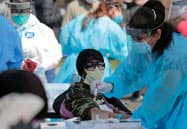 28日、市民の新型コロナ感染の有無を調べる医療関係者(ミシガン州デトロイト)=ロイター 28日、市民の新型コロナ感染の有無を調べる医療関係者(ミシガン州デトロイト)=ロイター