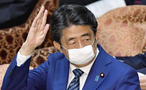 衆院予算委で答弁のために挙手する安倍首相(29日午前)=共同