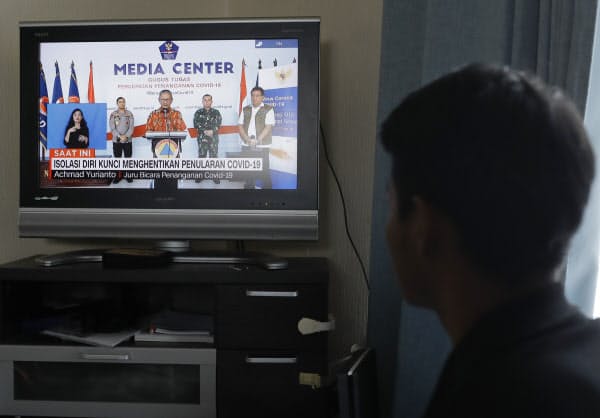 実習生の寮で動画配信サイト「YouTube(ユーチューブ)」を見るストリヨさん。ニュースで伝えられる母国の新型コロナウイルスの拡大に母親を案じる(4月)