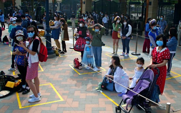 間隔を空けて入場を待つ来園者(11日、中国・上海ディズニーランド)=AP
