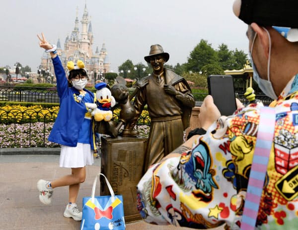 再開した中国・上海ディズニーランドで記念撮影を楽しむ来園者(11日)=共同