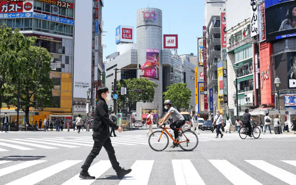 人通りの少ない繁華街をマスクを着けて歩く人たち(17日、東京都渋谷区)