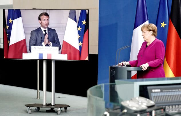 テレビ会議で共同記者会見したメルケル氏(右)とマクロン氏=ロイター テレビ会議で共同記者会見したメルケル氏(右)とマクロン氏=ロイター