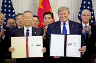 トランプ氏(右)は第1段階合意の破棄もちらつかせている(1月、ホワイトハウスで開いた署名式)=ロイター トランプ氏(右)は第1段階合意の破棄もちらつかせている(1月、ホワイトハウスで開いた署名式)=ロイター