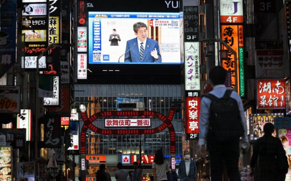 緊急事態宣言の全面解除を表明する安倍首相が大型ビジョンに映る(東京都新宿区)=野岡香里那撮影