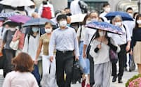 マスクを着けて出勤する人たち（25日、大阪市北区）