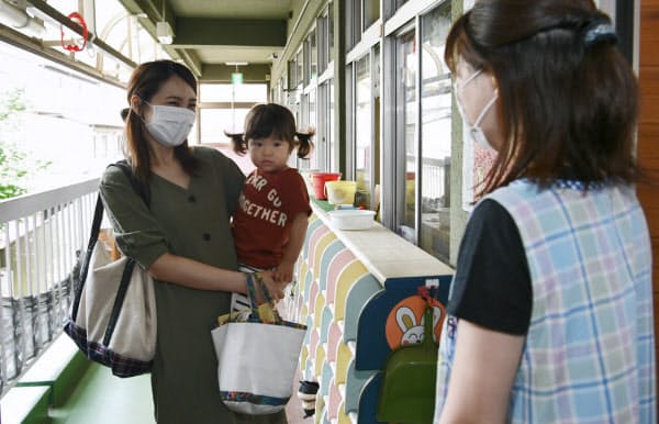 保育園に子どもを預けに来た母親(26日午前、東京都板橋区の舟渡保育園)=中岡詩保子撮影