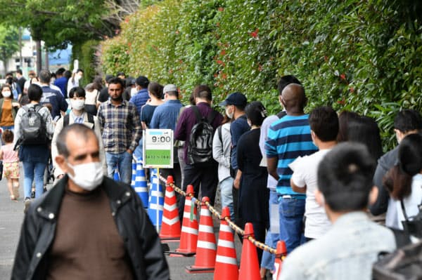 東京入国管理局に並ぶ在留外国人ら(26日午前、東京都港区)=藤井凱撮影