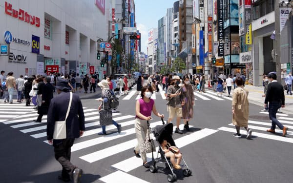 緊急事態宣言が全面解除された初の週末を迎え、新宿の街頭を行き交う人たち(30日午前、東京都新宿区)