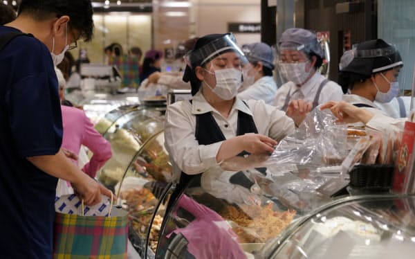 フェースシールドをつけて接客(30日午前、東京都新宿区の伊勢丹新宿本店)
