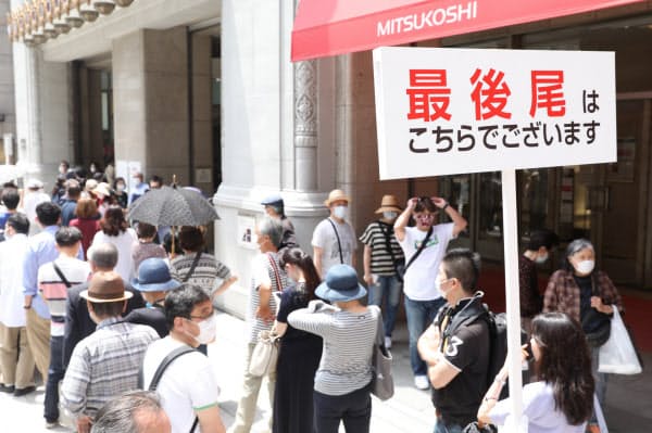 営業再開で日本橋三越本店に並ぶ人たち(30日、東京都中央区)
