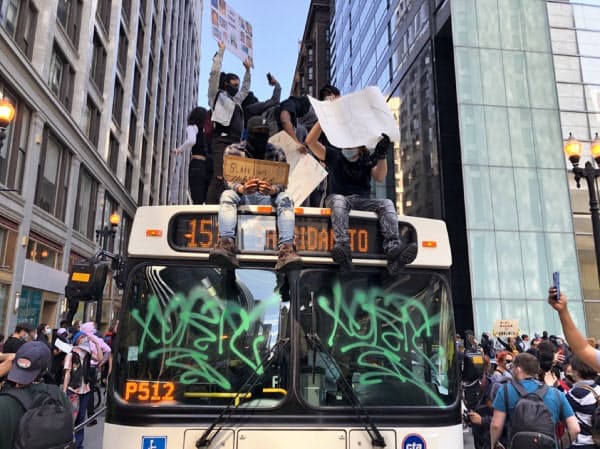シカゴでは一部のデモ参加者が市営バスの屋根に上り、「正義がない限り、平和はない」と訴えた（30日）