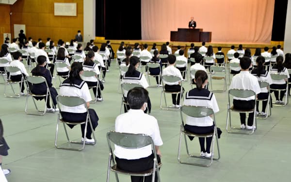 新型コロナウイルス感染予防のため、間隔を空けて座り、学年集会に臨む東京都立富士高校付属中の生徒ら（1日、東京都中野区）=共同