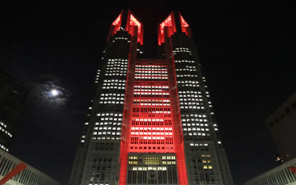 東京アラートが発動され、赤色に点灯された東京都庁(2日、東京都新宿区)