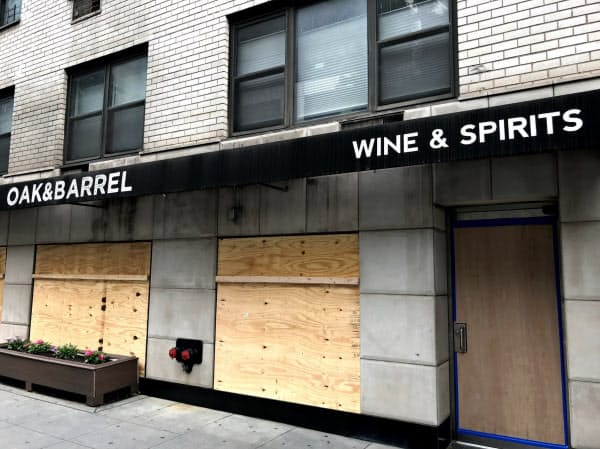 営業中だった酒屋も襲撃対策の板を張り、営業休止に追い込まれた(2日朝、ニューヨーク)