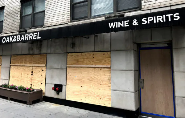営業中だった酒屋も襲撃対策の板を張り、営業休止に追い込まれた(2日朝、ニューヨーク)