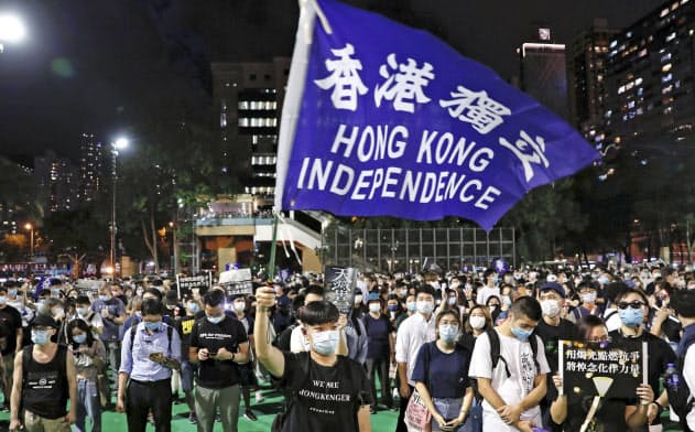 　香港のビクトリア公園での天安門事件追悼集会で「香港独立」と書かれた旗を振る参加者＝４日（ロイター＝共同）
