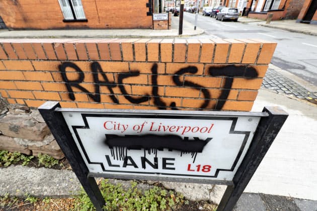 塗料で「ペニー」の部分が消された「ペニー・レイン」の表示板。後方には「人種差別主義者」と書かれている（12日、英リバプール）＝ＡＰ
