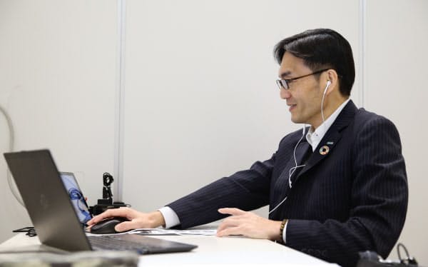 ウェブ中心の就活は学生の内定獲得や辞退の様子も変えている(画面に映る学生を面接する大手企業の採用担当者)