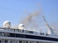 火災が発生し、煙を上げるクルーズ船「飛鳥2」(16日午後2時13分、横浜港)=共同 火災が発生し、煙を上げるクルーズ船「飛鳥2」(16日午後2時13分、横浜港)=共同